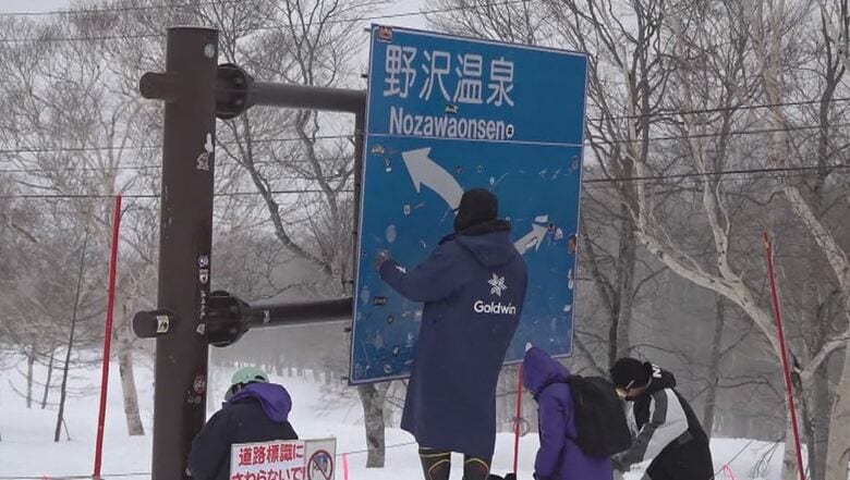 道路標識のステッカーをはがす