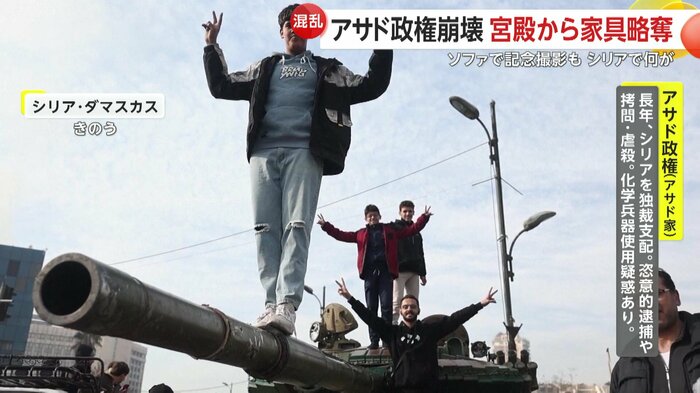 戦車の上でピースサインをする市民