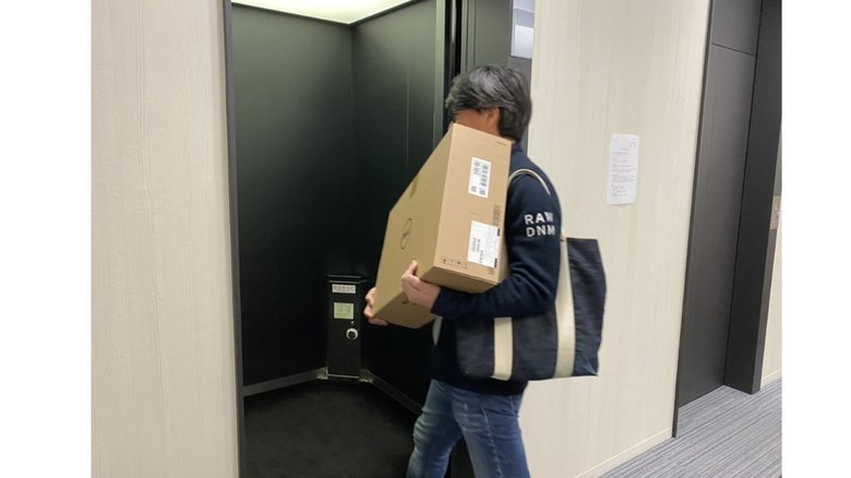 モニターとノートパソコンを持ち帰る社員
