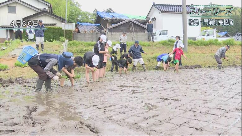 教わりながら田植えをする子どもたち