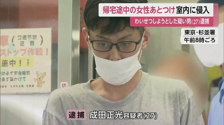 警察官に連れられ、無表情で歩く成田容疑者（東京・杉並区 21日午前8時ごろ）