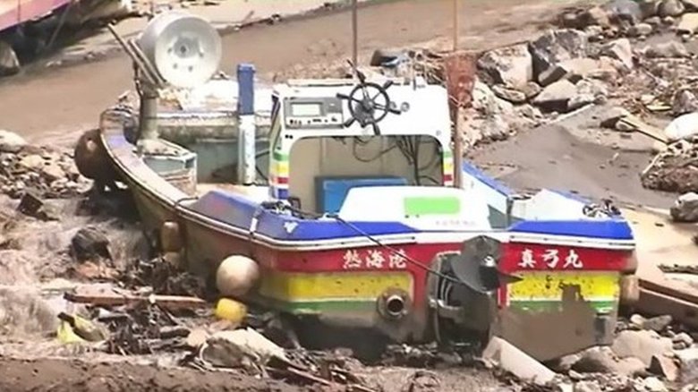 土砂に打ち上げられた漁船　泥はひざの高さまできていた