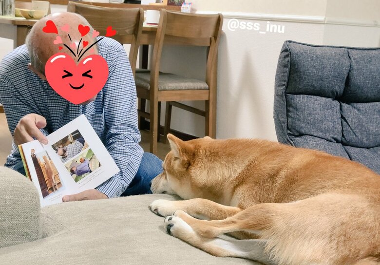 麦くんに写真集を見せているお父さん（提供：犬さん）