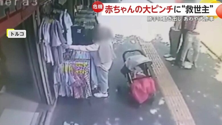 ベビーカーから手を離し、店先のTシャツを選び始めた母親