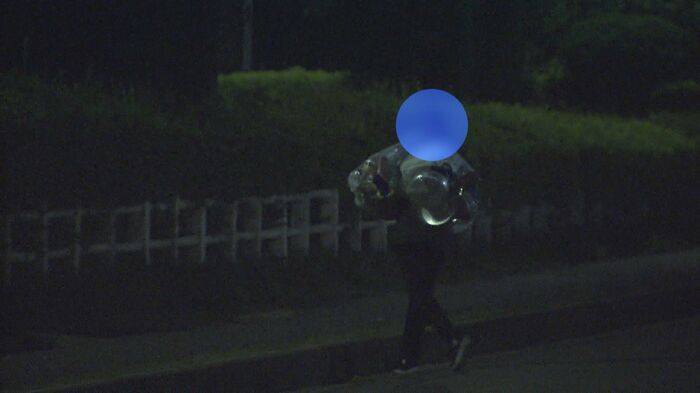 団地から袋を持ち去る男性