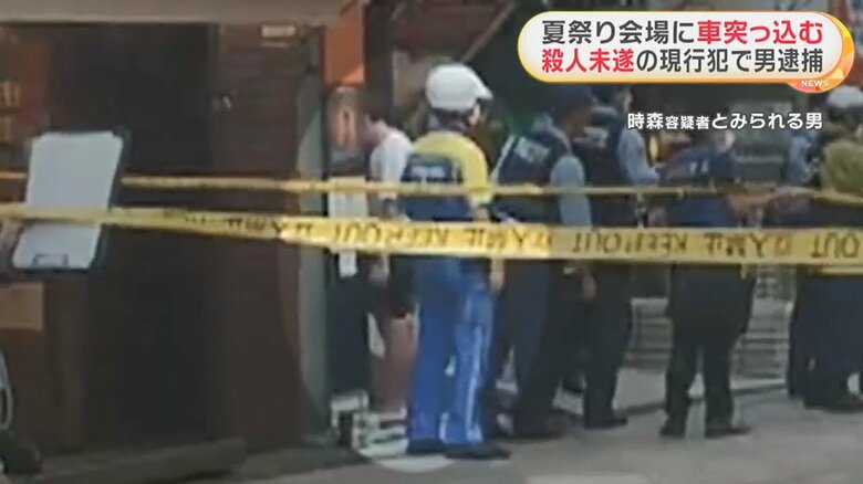 警察官の近くで立ち尽くす時森容疑者とみられる男