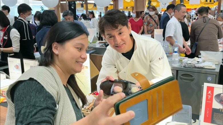 タイ人客の撮影依頼に応じる内田さん