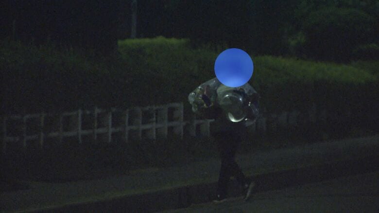 団地から袋を持ち去る男性