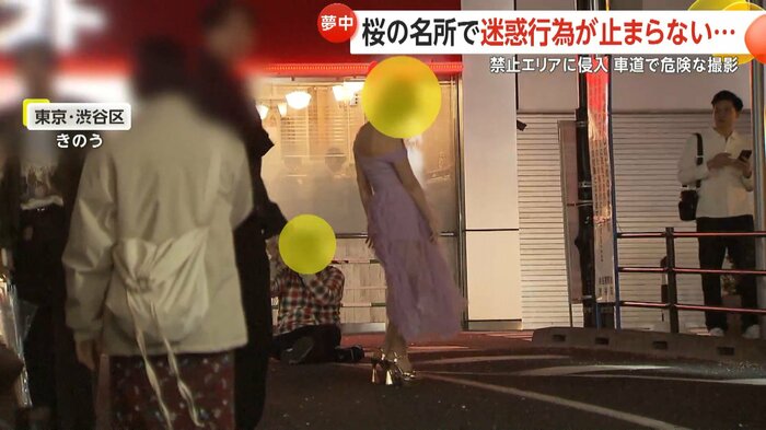 道端に座り込んで撮影する人が