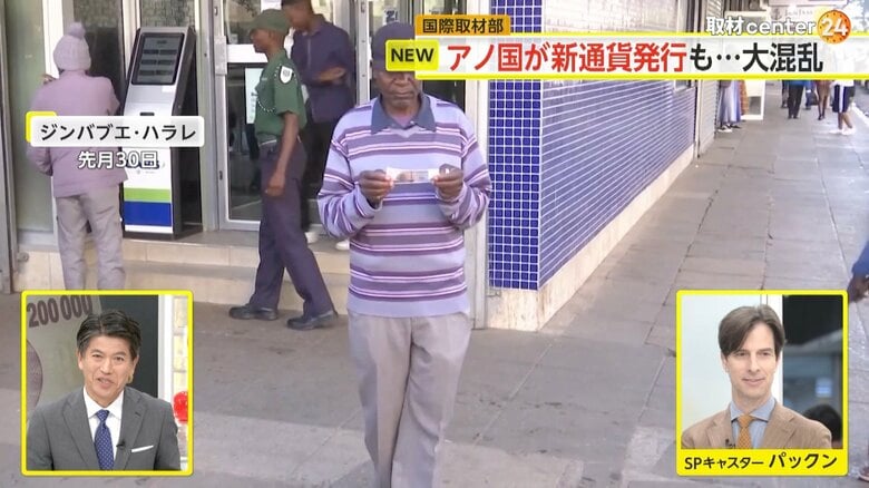 新通貨を受け取り、もらった紙幣を不思議そうに眺める男性