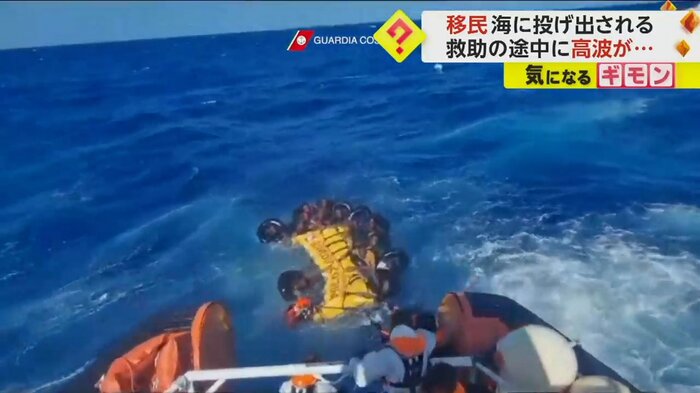 隊員と移民たちが救助船へ向かう