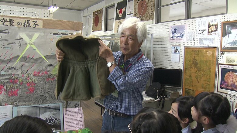資料館で子どもたちに戦争を語り伝える木原さん