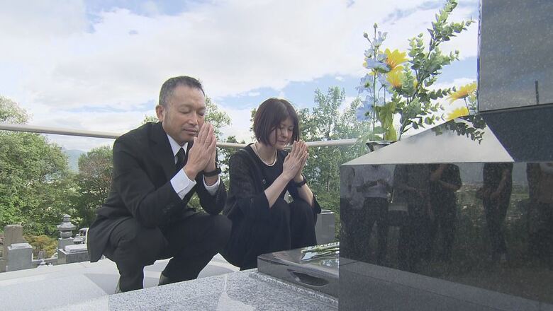 律希さんの墓に手を合わせる両親