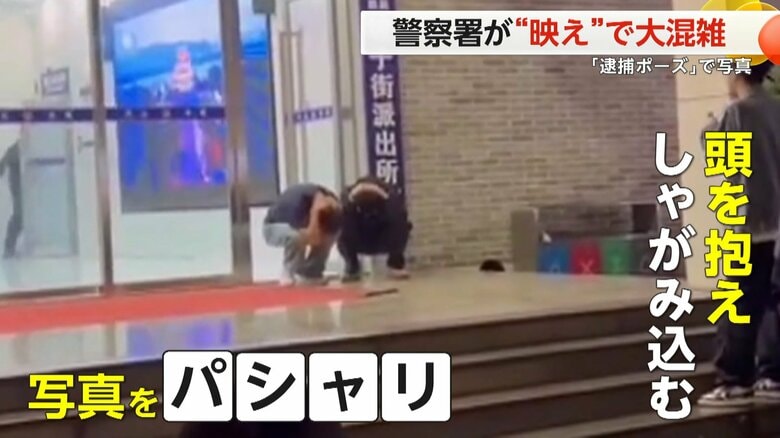 中国・湖南省の警察署の前で、頭を抱えてしゃがみ込んで記念撮影する人