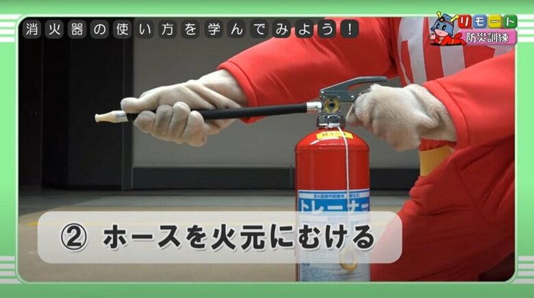 消火器の使い方（2）ホースを火元にむける（提供：東京消防庁）