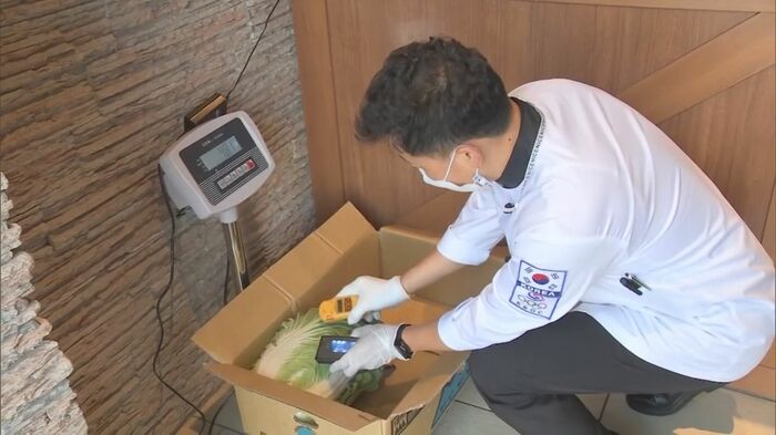 韓国が運営する給食支援センターでは日本産食材に放射線測定器をかざす「検査」が行われている