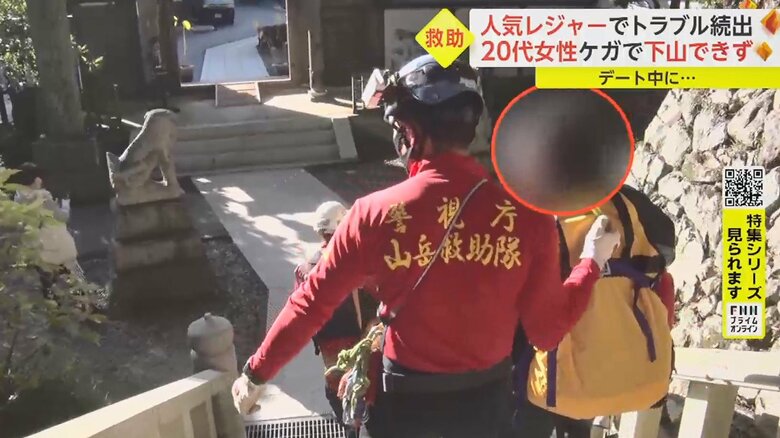 登山客に「道を空けてください」と呼びかけながら、慎重に階段を下りていく