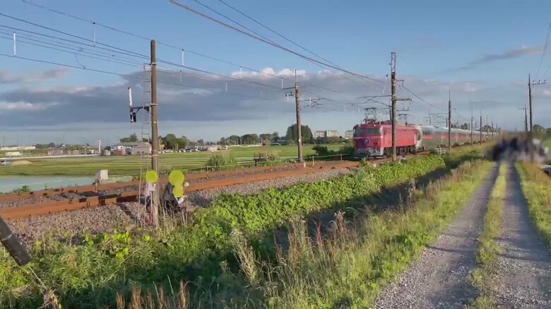 カシオペアが迫る中、3人組が線路の近くにいるのが見える