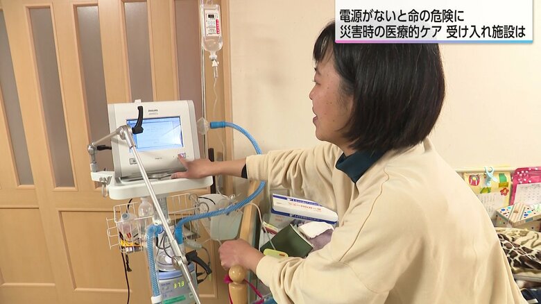 脳性まひの健太郎さんが使用している人工呼吸器を操作する母・かおりさん
