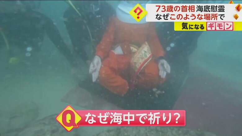両側を支えられながら海底に座るモディ首相