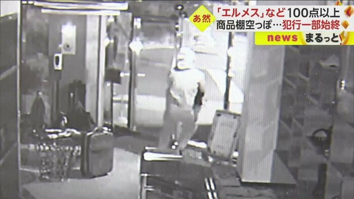 バッグを両手いっぱいに抱え、駆け足で出て行く男