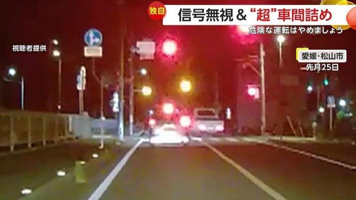 赤信号を無視して追い越していく軽トラック