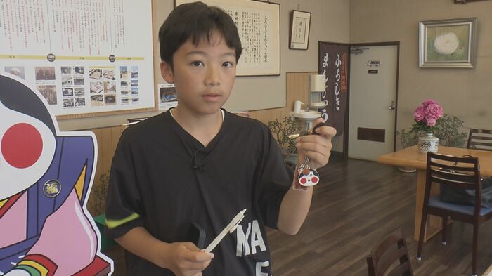 山本おたふく堂の「ふろしきまんじゅう」グッズを手にする羽原瑠良くん