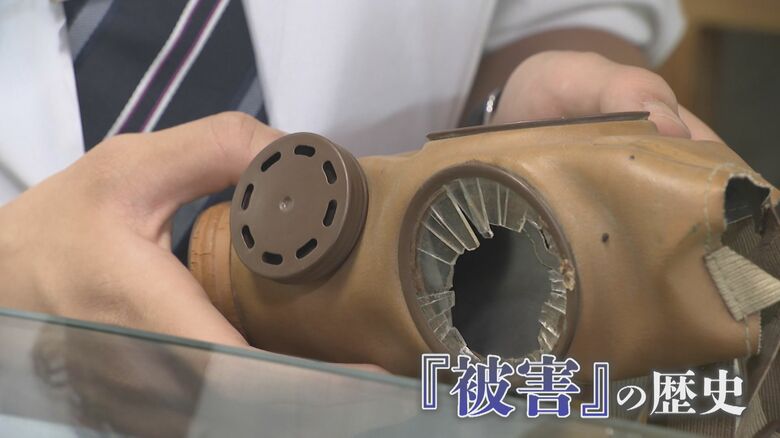 防毒マスクを手にする青柳潤さん