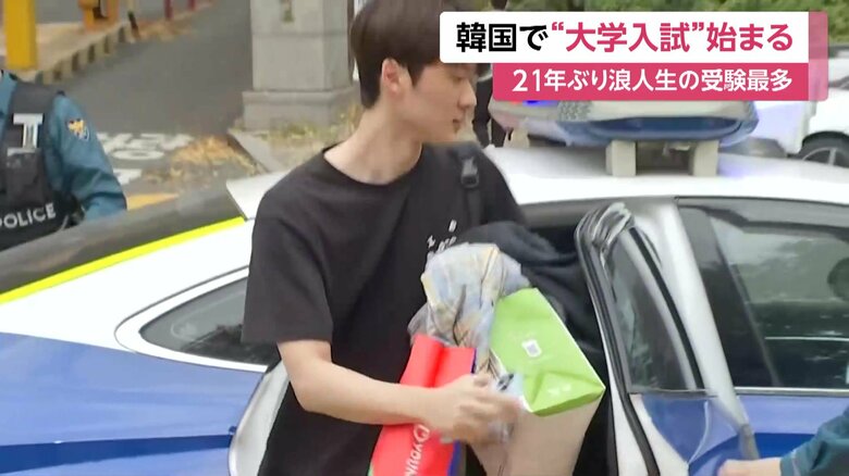 パトカーで会場入りする受験生