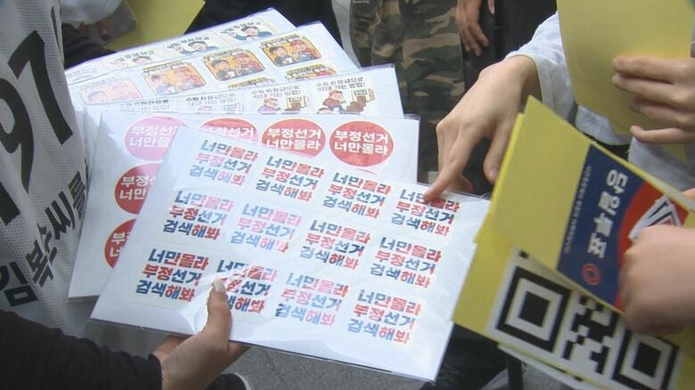 保守派の支持団体がステッカーを配る（29日撮影）