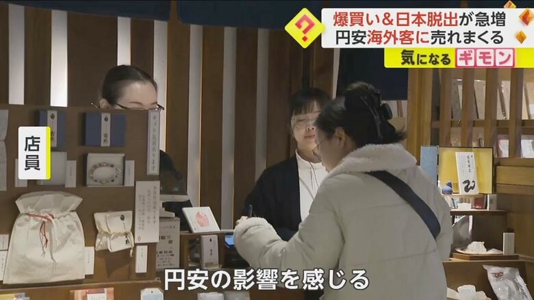 和風の小物を扱う店で買い物をする観光客の姿
