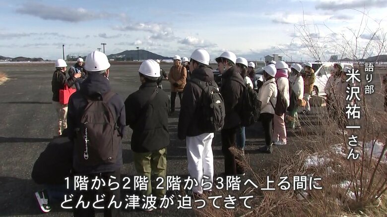 震災遺構の「米沢商会ビル」の前で震災の記憶を伝える語り部・米沢祐一さん